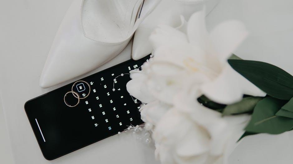 Flat lay of wedding essentials including high heels, rings, and a bouquet on a calendar.